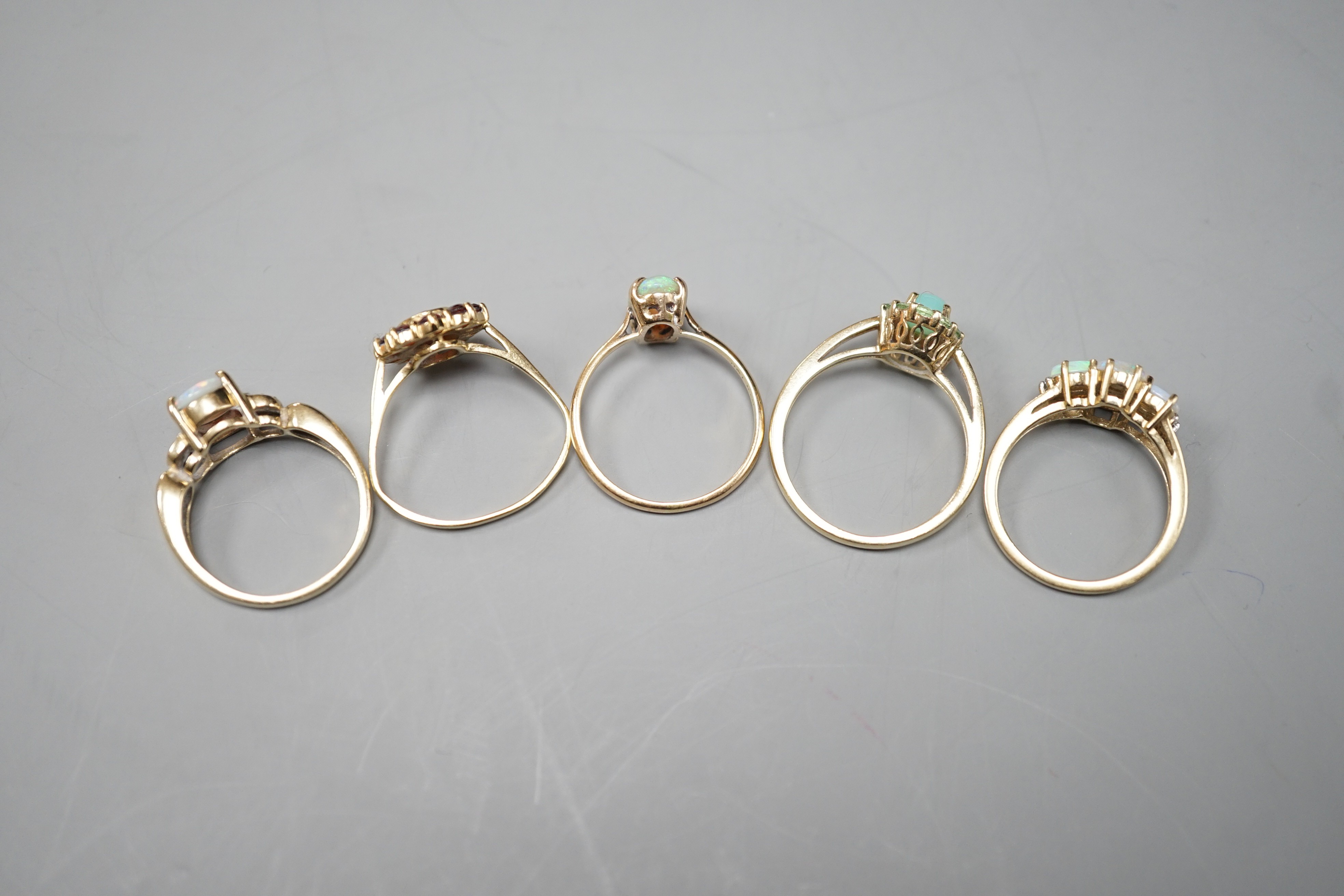 Five assorted modern 9ct gold and gem set dress rings, including white opal and diamond chip cluster, white opal cluster and garnet cluster